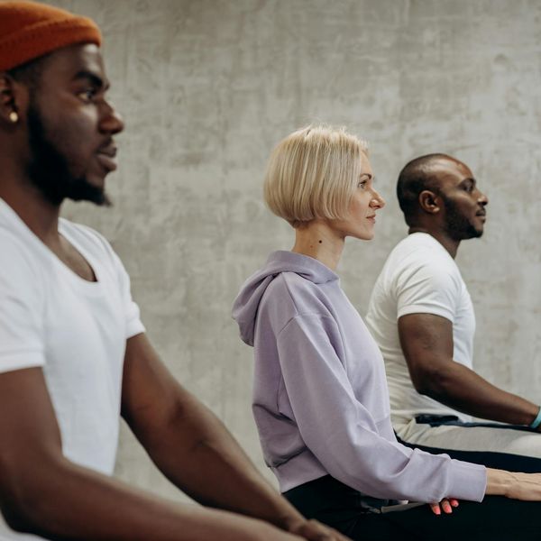 A diverse group of people of different ages and abilities in a welcoming yoga class.